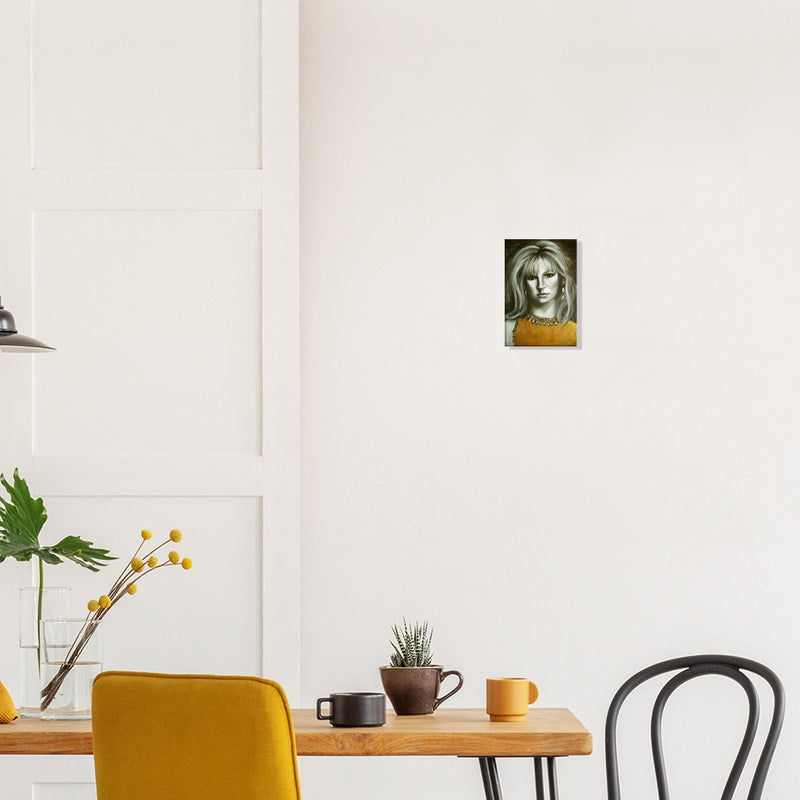 Modern dining area with yellow chair, wooden table, plant, and small portrait painting on white wall