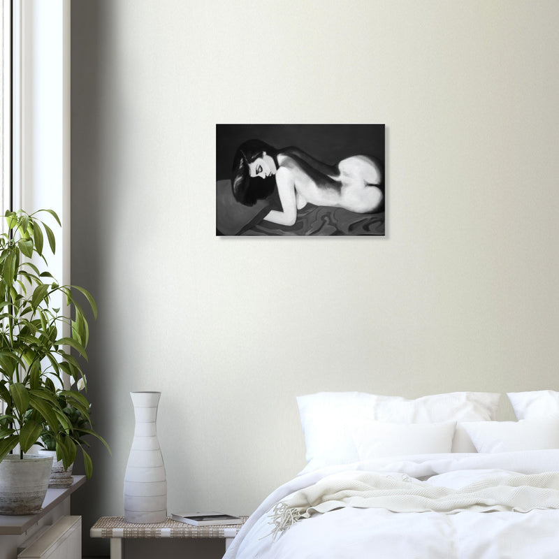 Black and white painting of a reclining nude woman with dark hair on a bed, hung above a white bed