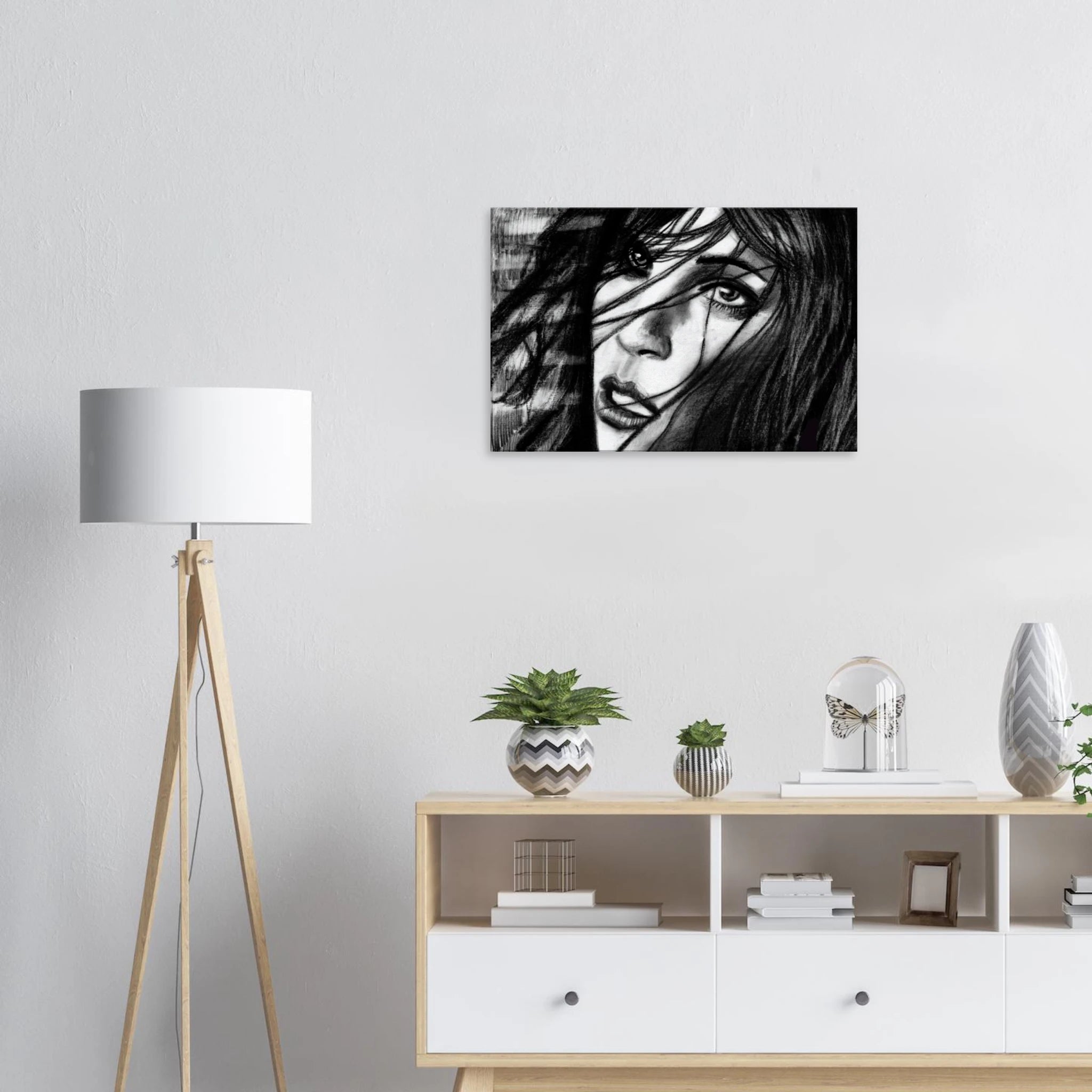 Modern living room with black and white female portrait artwork above wooden sideboard and tripod floor lamp