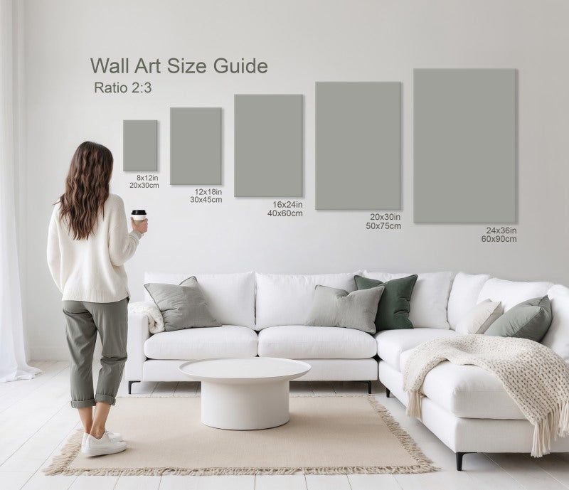 Woman holding coffee cup standing in front of a size guide showing different wall art dimensions above a white sectional sofa.